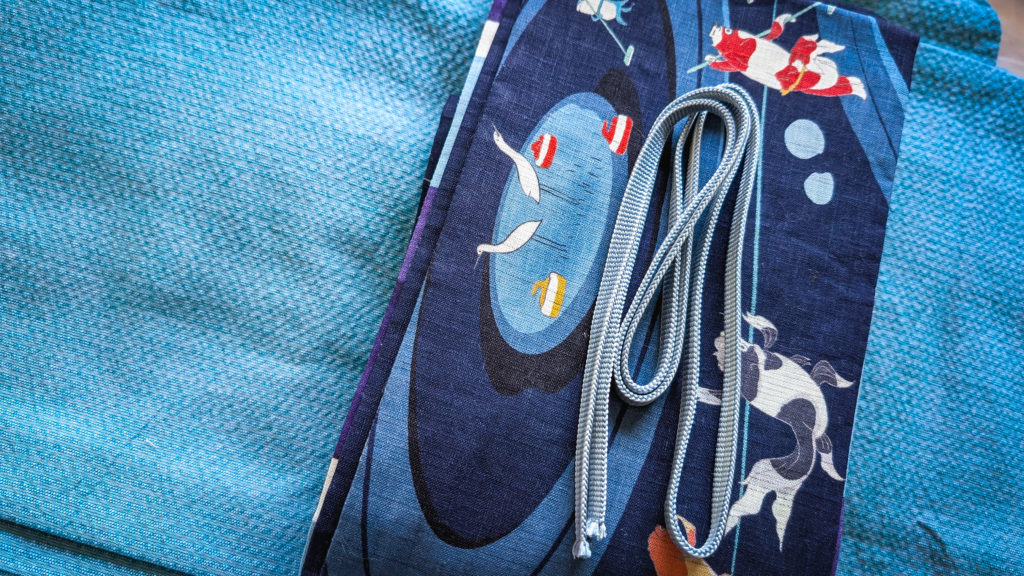 Blue kimono and blue obi with gold fish illustration